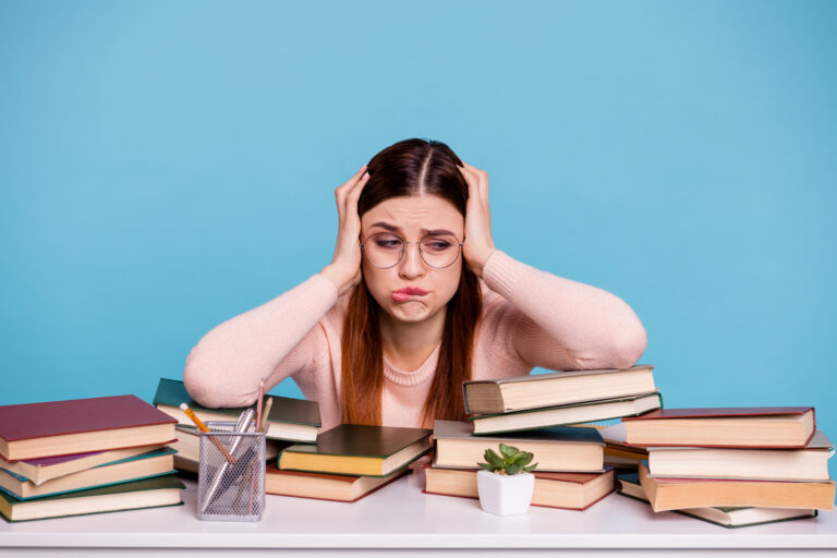 Jeune femme stressée et débordée au milieu de livres
